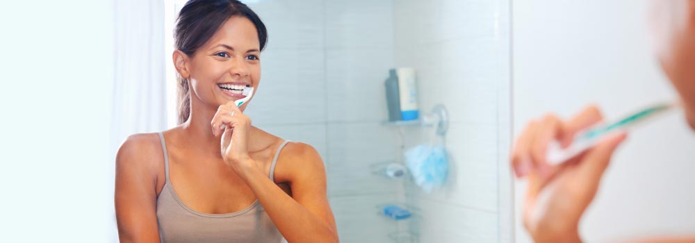 Young woman shows How To Brush Your Teeth